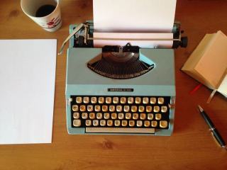 Working notes for a ghostwritten celebrity memoir Recording device and a stack of typed manuscript pages on a desk